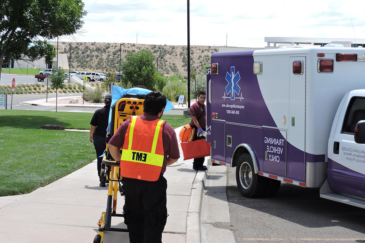 EMS students prepare gurney and program Ambulance for a classroom 